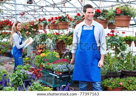Young smiling florists working in the greenhouse.