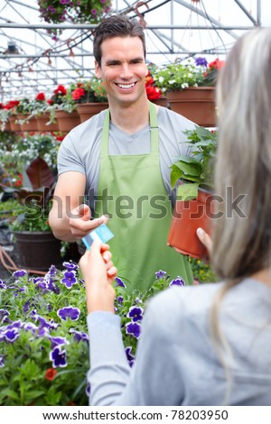 Young smiling seller florists working in flower shop.