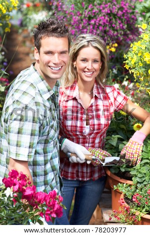 Gardening. Young smiling people florists working in the garden. .