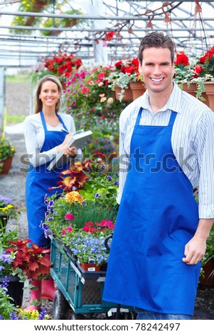 Young smiling florists working in the greenhouse.