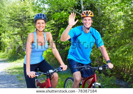 Happy smiling couple  riding  in the park