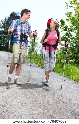 Couple with backpacks and trekking poles. Adventure.