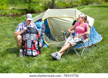 Happy young couple with big tent. Camping.