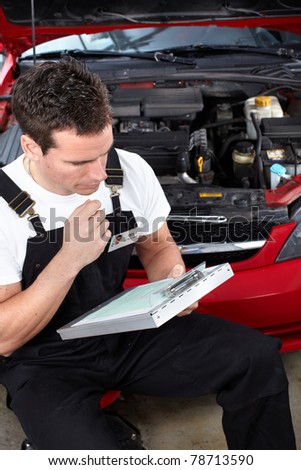 Handsome mechanic working in auto repair shop.
