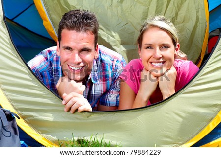 Happy young couple with big tent. Camping.