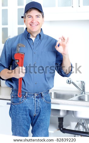 Happy professional plumber doing sink reparation. Contractor.