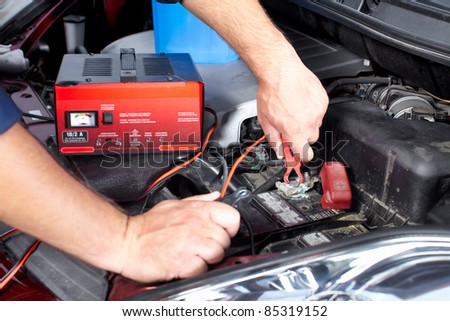 Battery charger and car in auto repair shop.