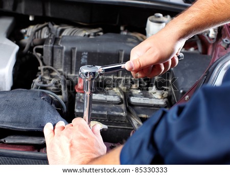 Hands of mechanic working in auto repair shop.