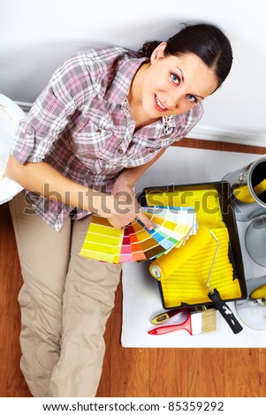 Young woman doing renovation interior wall of home.