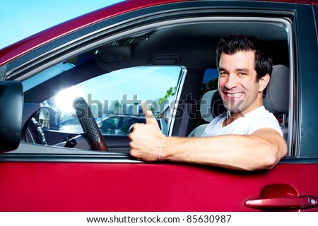 Happy smiling man in new car. Driving.