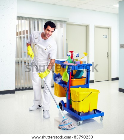 Young professional cleaner washing the floor. Janitor cart.
