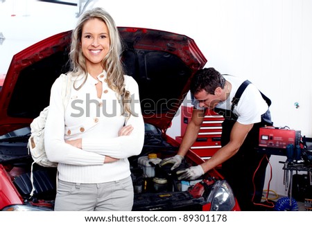 Professional auto mechanic and woman in auto repair shop. Garage.