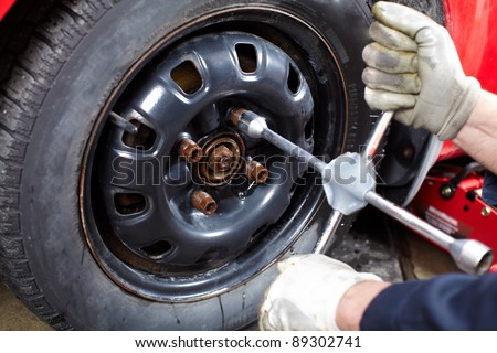 Professional auto mechanic changing a tire in auto repair shop. Garage.