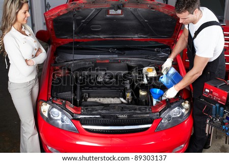 Professional auto mechanic and woman in auto repair shop. Garage.