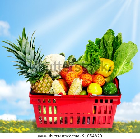 Grocery shopping basket with food. Over blue background.
