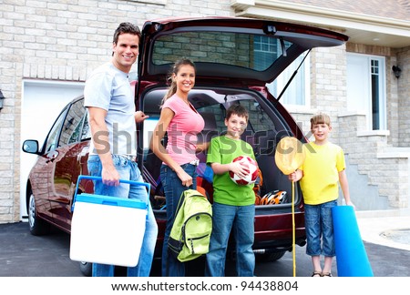 Smiling happy family and a family car.