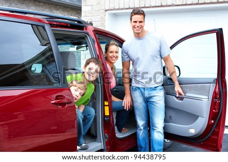 Happy smiling family and a family car.