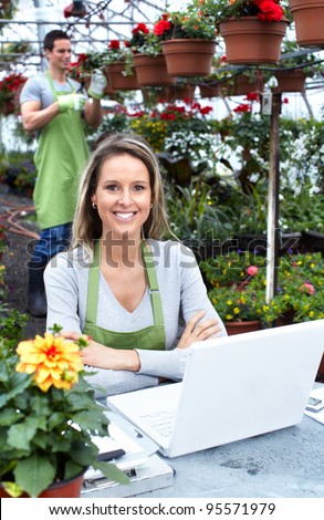 Florists couple working with flowers at a greenhouse. Gardening.
