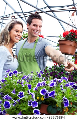 Florists couple working with flowers at a greenhouse. Gardening.