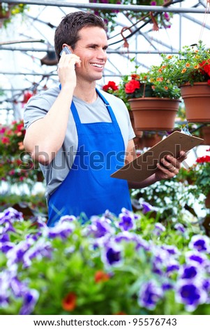 Florist man working with flowers at a greenhouse.