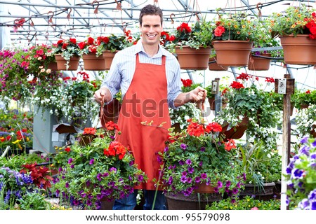 Florist man working with flowers at a greenhouse.