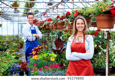 Florists couple working with flowers at a greenhouse.