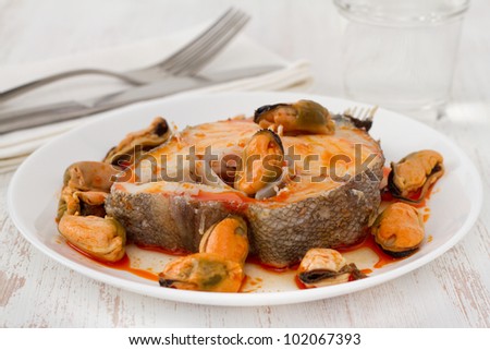 boiled fish with sauce and mussels on the white plate