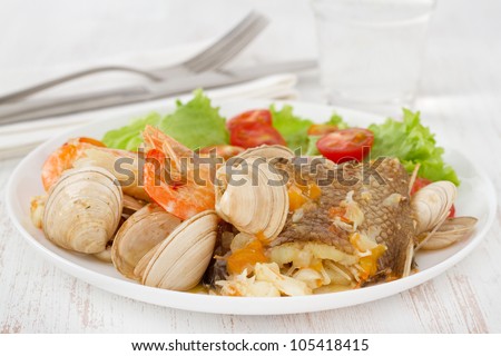 fish stew with salad on the white plate
