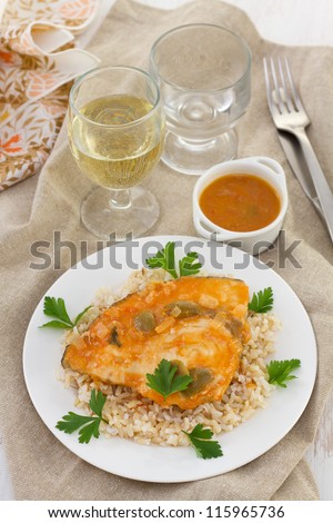 fish with sauce and boiled rice and glass of wine