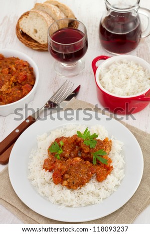 meatballs in sauce with boiled rice and glass of wine