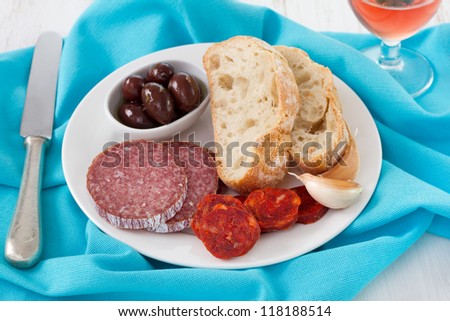 smoked sausages with bread and olives in olive oil