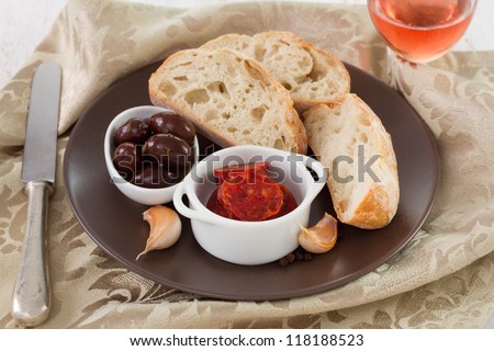 smoked sausages in bowl with olives and bread