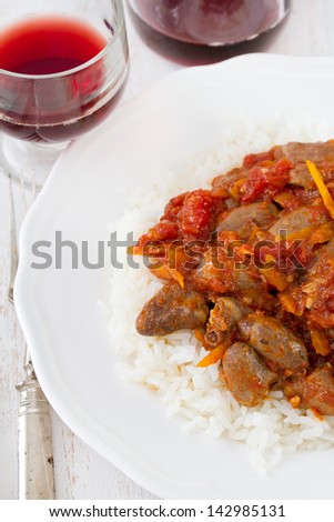 chicken hearts with rice and glass of red wine