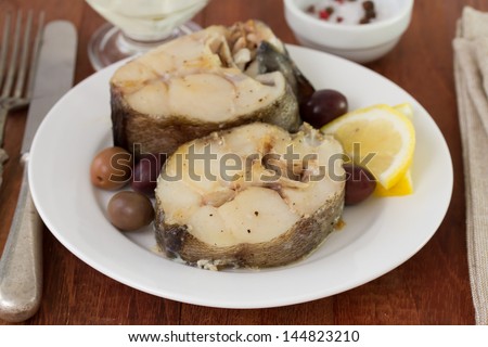 boiled fish with lemon on the plate