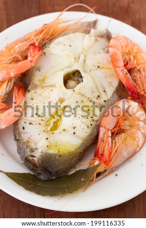 boiled fish with shrimps on white plate