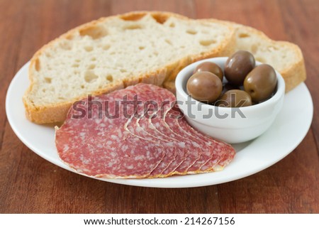 sausage with bread and olives in bowl
