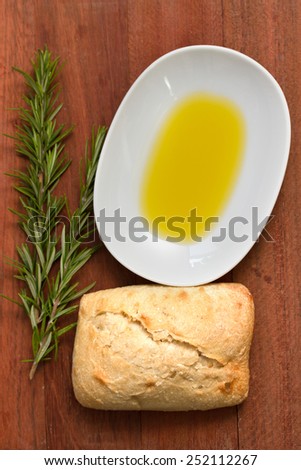 rosemary, bread and oil on brown background