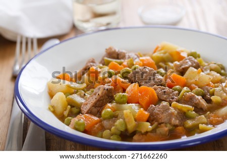 meat with carrot, peas and potato on plate