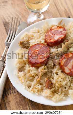 portuguese dish duck rice on white plate with wine