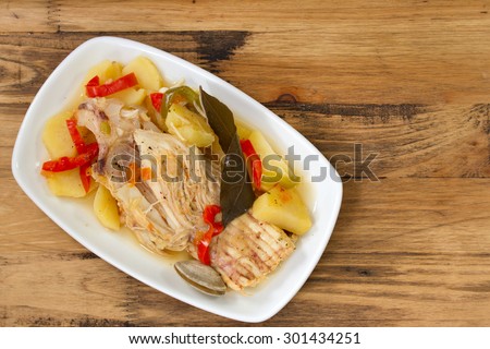 fish stew on white dish on brown wooden background