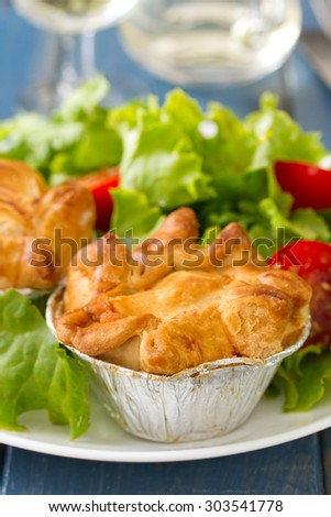 pie with chicken with salad on white plate and glass of wine