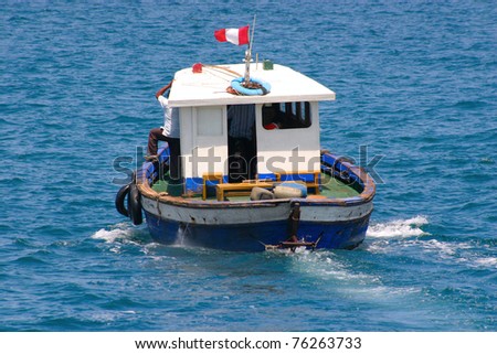 Old boat with cabin is sailing away, visible aft and Peruvian flag
