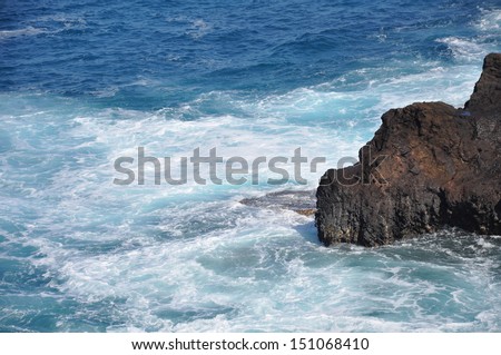 Turquoise waters swirl around rocks on the coast of Oahu, Hawaii