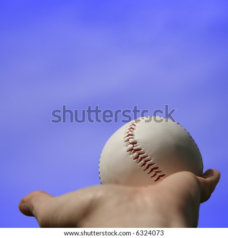 Baseball in Palm of Hand Against Blue Sky