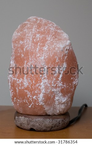 A salt lamp sits on a desk, turned off