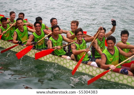 TUEN MUN, HONG KONG -  JUNE 16: Participants smile while paddling their boat during a dragon boat race on June 16, 2010 in Tuen Mun, Hong Kong