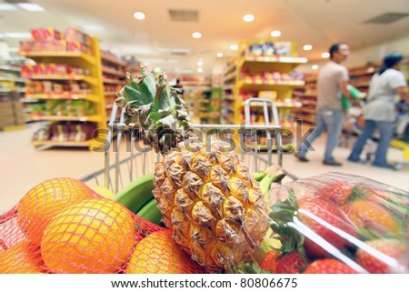 Moving shopping cart in supermarket. It was taken from the shopper\'s point of view.