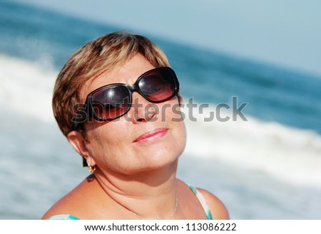 beautiful elderly woman sunbathing on the beach