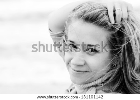 Portrait of young attractive woman near the sea on spring day