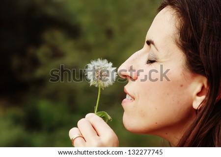 portrait young woman blowing dandelion